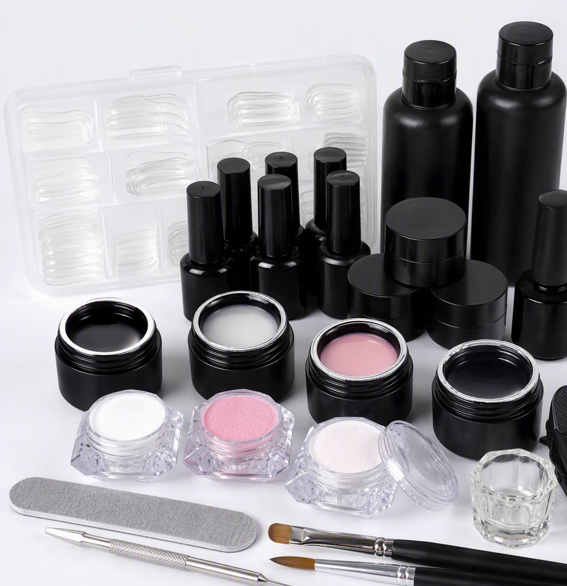 Kit completo de uñas: esmaltes en gel, polvo acrílico, tips y herramientas sobre fondo blanco